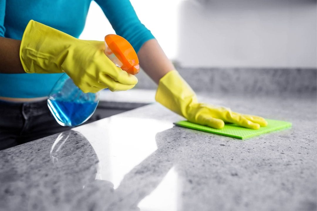 Lady cleaning kitchen granite countertops